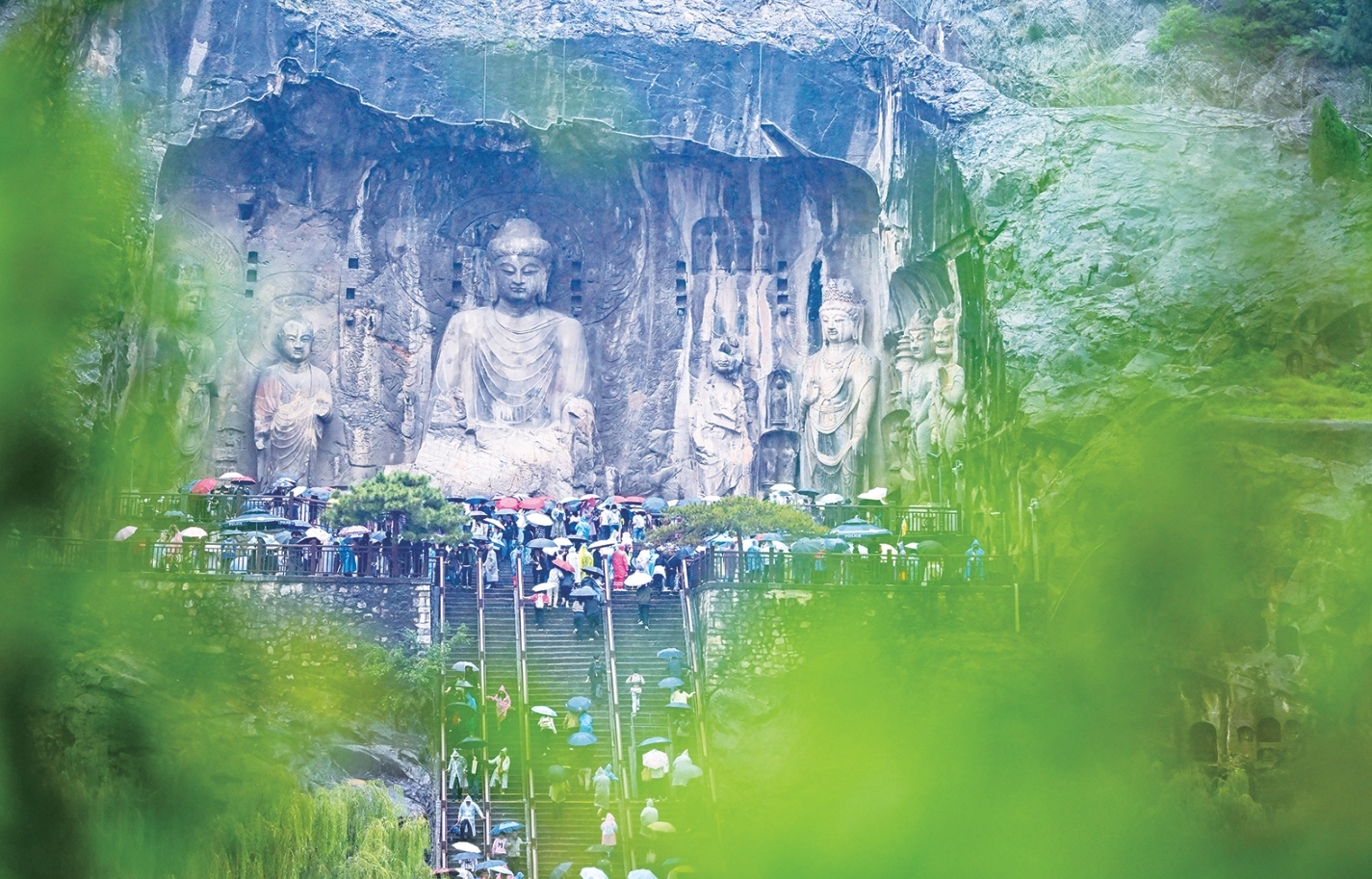 游客冒雨游览位于河南洛阳的龙门石窟。 (新华社发)